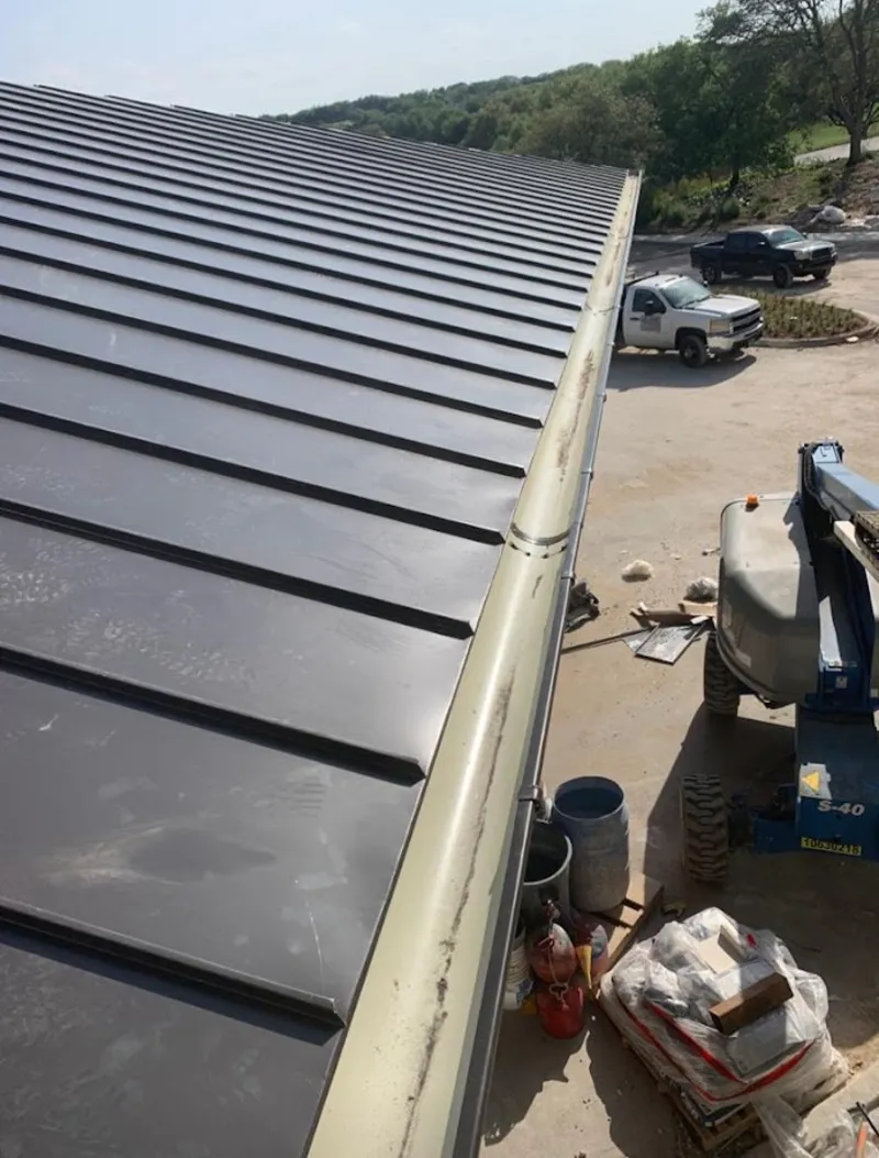Standing seam panel and gutter detail on a metal roofing jobsite in Balch Springs